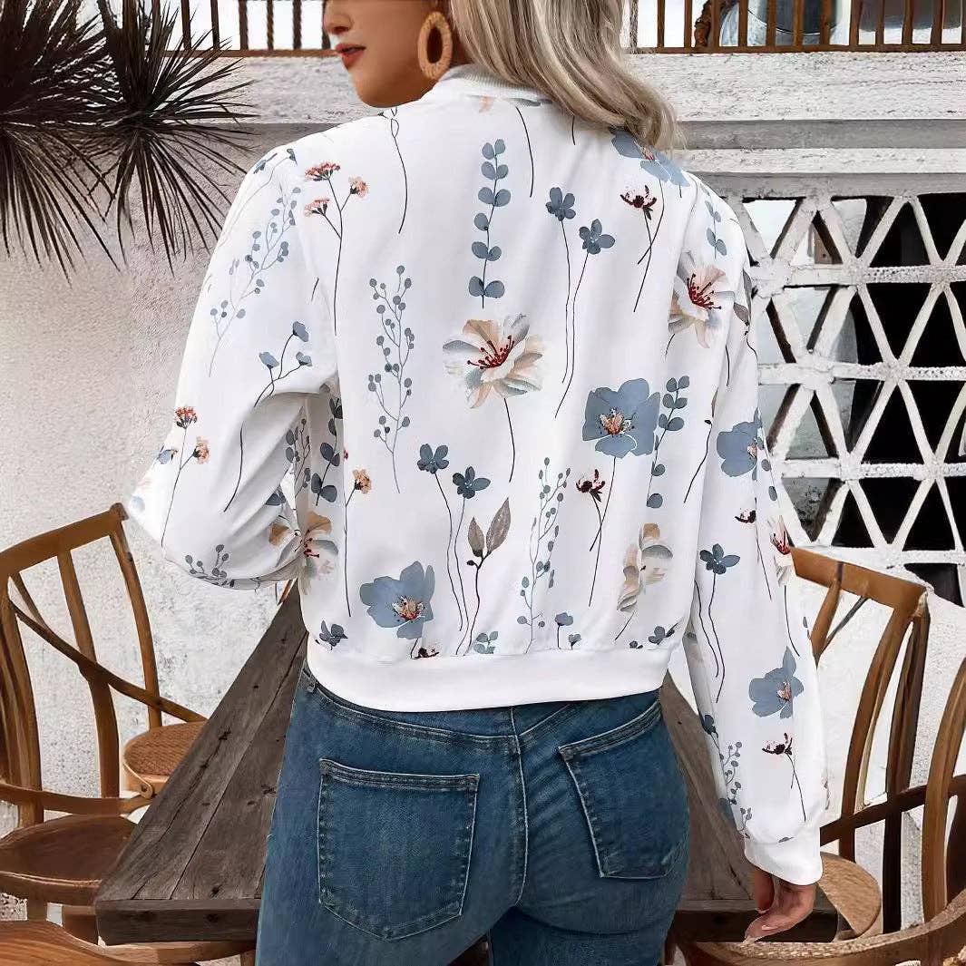 Person wearing a white floral blouse and blue jeans in an outdoor setting.